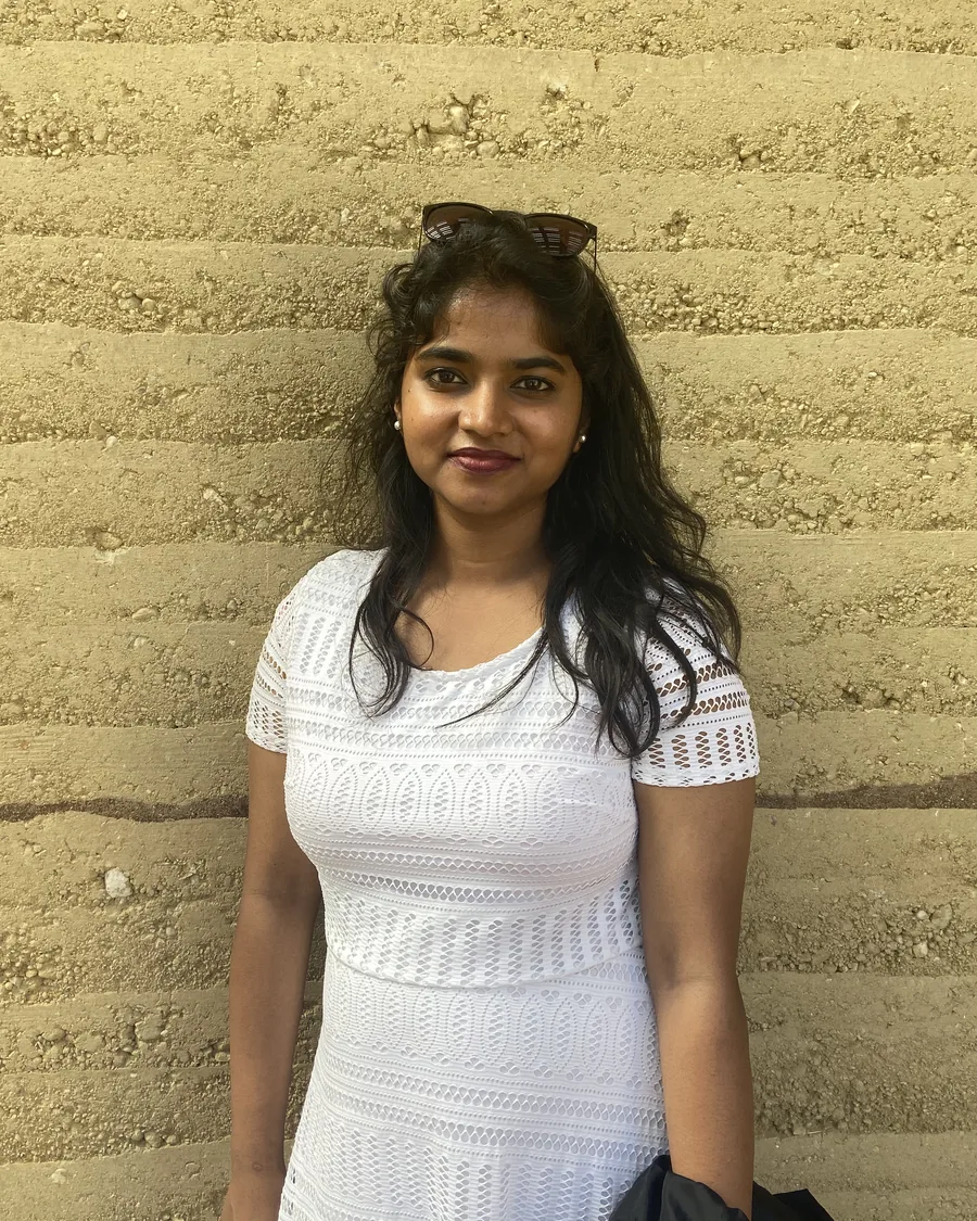 Tejaswini Krishna P., founder of Studio Nalm&eacute;, against a rammed earth wall
